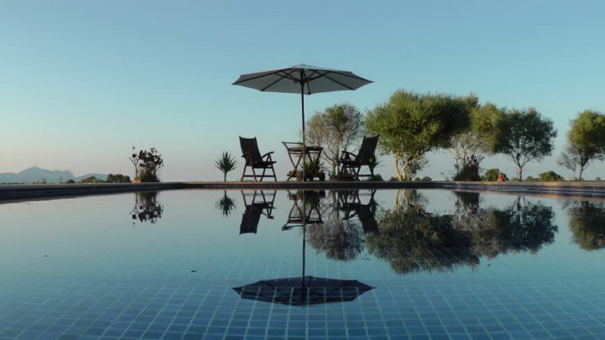 a pool with chairs and umbrella